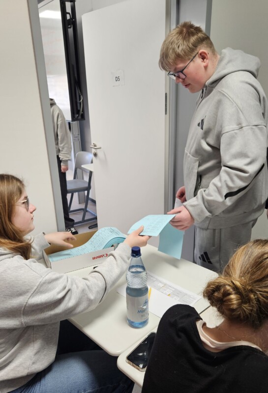 Schüler werfen Stimmzettel in die Urne